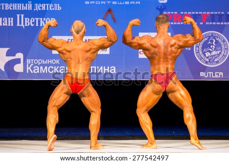 Perm, Russia - April 19, 2015.Cup Perm Krai  on bodybuilding and fitness bikini.  Two bodybuilder in red briefs show double biceps from behind