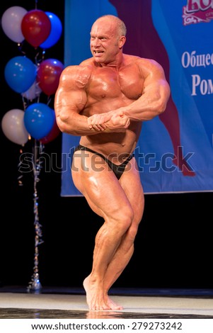 Perm, Russia - April 19, 2015.Cup Perm Krai  on bodybuilding and fitness bikini. Bald bodybuilder showing biceps standing side