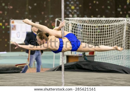 Perm, Russia - April 25, 2015. Championship Perm region at pole sport and dance. young girl in a blue swimsuit making element Jenyne split