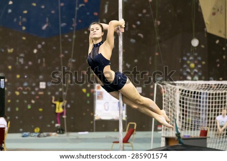 Perm, Russia - April 25, 2015. Championship Perm region at pole sport and dance.  The brunette in a black swimsuit makes the element dove