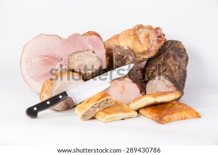 Meat delicacies, meat layer cake and knife on white background