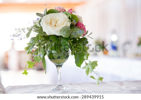 Flower arrangement of white roses and ivy is a crystal glass