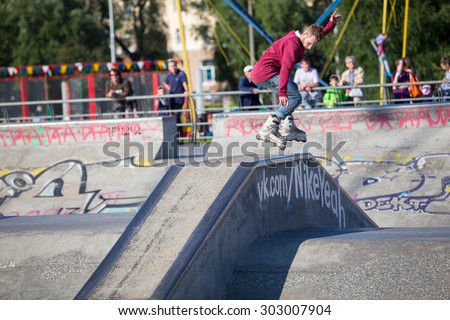 Perm, Russia - July 26, 2015. Free access to the Extreme Park in the city of Perm. Red-haired young man in a red shirt and jeans jumping on the rollers through a concrete pile