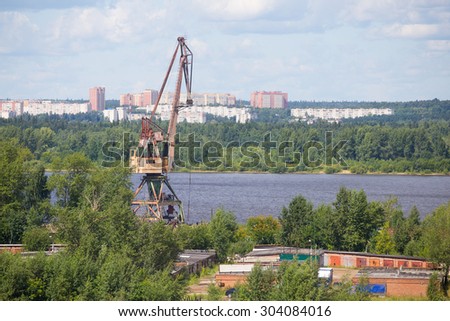 Aerial photos of the crane next to the river on the background of the city