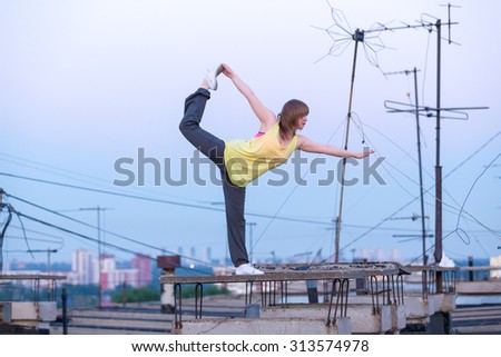 relaxing yoga on the roof on background antenna at sunset