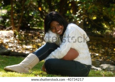 African-American woman sitting down outside with a football