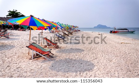 Relaxing scene on a breezy day at the tropical beach; two deck chair and umbrella