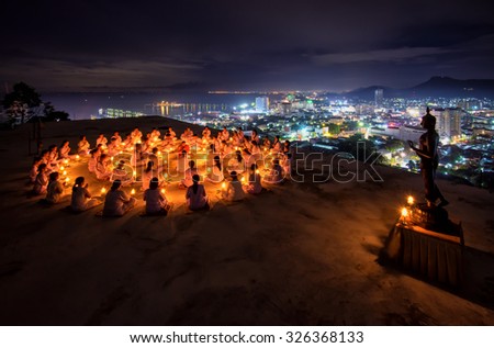 Chonburi, THAILAND - October 10: Thai monks and buddhist prayers and meditation with buddha statue among many candle at Watkhaophrakru Srirach temple on October 10, 2015 in Chonburi, Thailand.