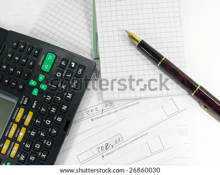 Fountain pen calculator notepad and bills over white