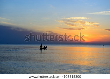Fisherman are taking fishing boat to fish with sunrise background in thailand
