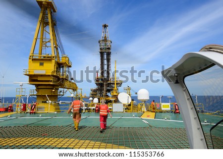 The helicopter landing officer are walking back after take care passenger to embark helicopter at oil rig platform is in the gulf of Thailand.