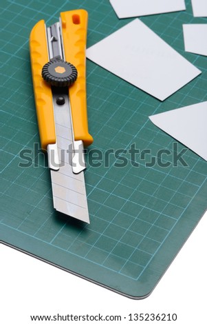 Box Cutter Knife just Cutting white paper on cutting mat isolated on white background