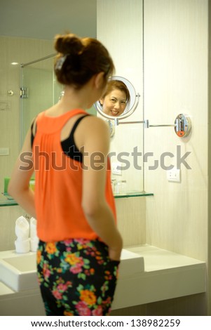 beautiful asian woman smile with mirror in bathroom