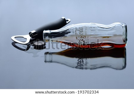 BANGKOK, THAILAND - SEPTEMBER 1, 2012: Classic bottle of Coca-Cola lie next to the bottle opener