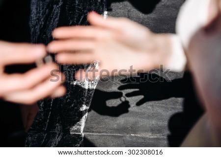 he shadow of a pair of hands is not Stine. The groom wears the ring bride. The wedding ceremony outdoors.