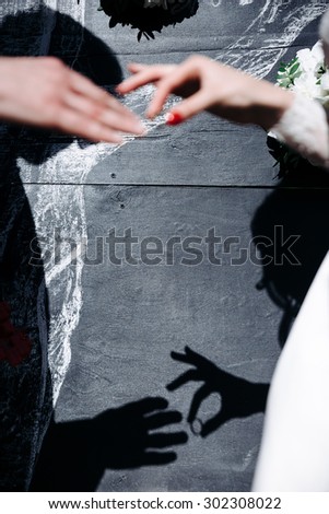 he shadow of a pair of hands is not Stine. The groom wears the ring bride. The wedding ceremony outdoors.