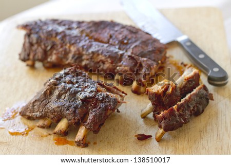 Sweet and spicy baby back ribs on a cutting board.
