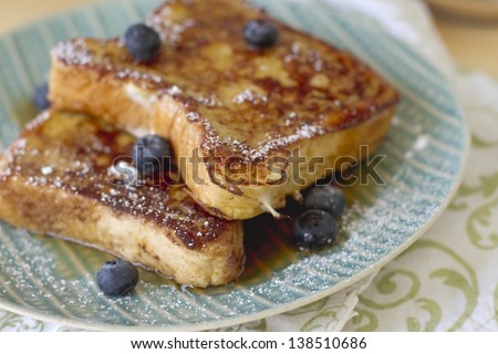 French toast with powdered sugar and maple syrup.