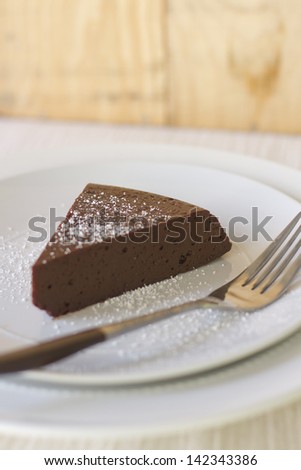 A piece of flourless chocolate cake with powdered sugar.