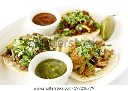A beef, carnitas, and chicken taco with salsas.