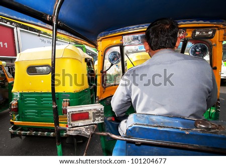 NEW DELHI, INDIA - MARCH 09 : Auto rickshaw taxis on a road on March 09, 2012 in Delhi, India. These iconic taxis have recently been fitted with CNG powered engines in an effort to reduce pollution