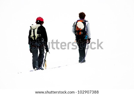 Team of two alpinists climbing a mountain during foggy weather