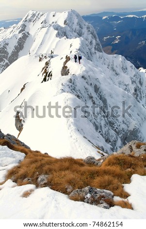 Team of two alpinists climbing a mountain