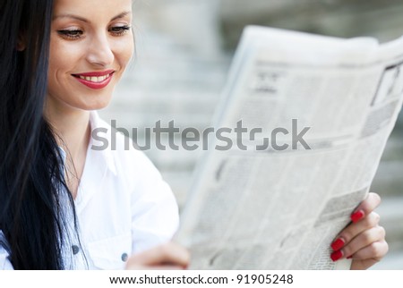 Young girl reading a newspaper during the job break