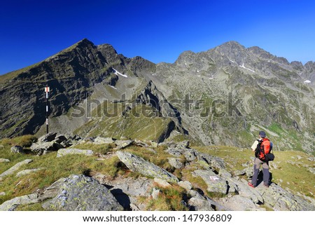 Nature photographer with digital camera trekking in the Transylvanian Alps, Romania, Europe