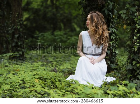 Art fashion portrait of young woman walking in the woods