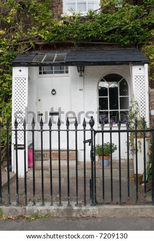 A Georgian Front door and porch with arched window and a front garden enclosed by Iron Railings on The Thames Path at Chiswisck