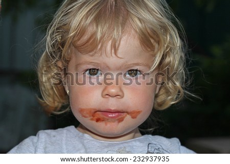 Little girl face is dirty with chocolate