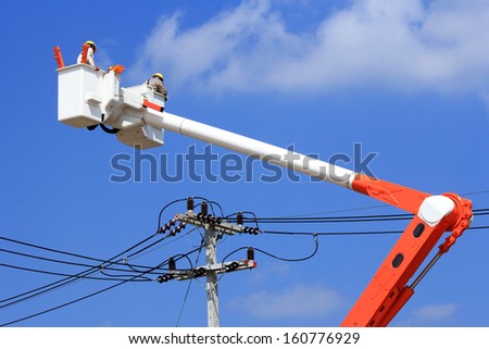 Electrician repair of  electric power system  on  hydraulic platform .