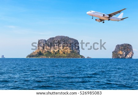 passenger plane airplane flying over above island in tropical blue sea.