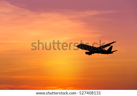 Silhouette airplane flying on sunset