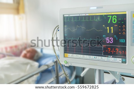 Close up  digital device for measuring blood pressure monitor with elderly patient sleep on the bed in hospital ward room