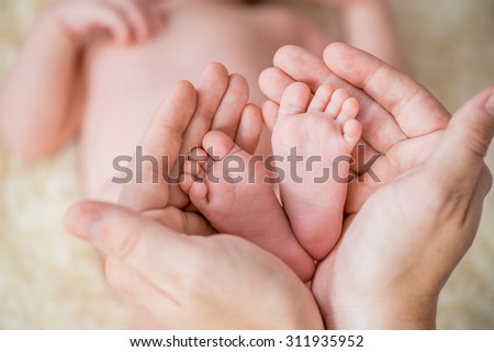 Feet of new born Baby in Hands of parents