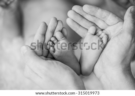 Feet of happy new born Baby in Hands of parent