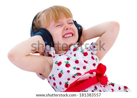 Charming little girl loves to listen to music through headphones.Isolated on white background.