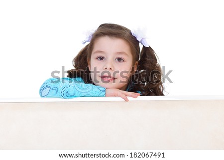 Portrait of happy little girl peeking over table isolated over white background