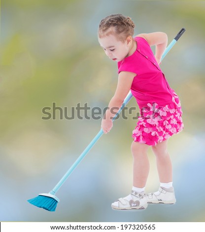 Sweet little girl sweeps the floor brush