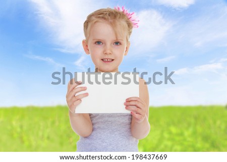girl holding a white envelope on a background of green meadow blue sky, on this envelope that you can write something.