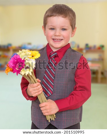 Smiling boy in a tie with a bouquet of flowers.child, happiness and people concept, lovely smiling toddler portrait