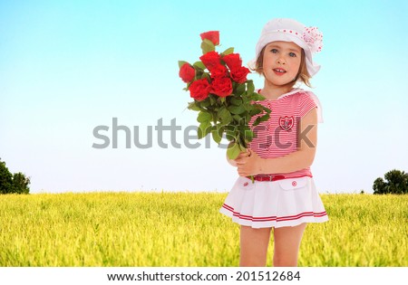Girl with a bouquet of roses in nature.spring season,fun outdoors,happy childhood,sweet child having fun outdoor,smiling toddler portrait
