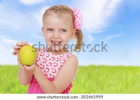 girl shows golden apple closeup.healthy food concept,active lifestyle,happiness concept,carefree childhood concept.