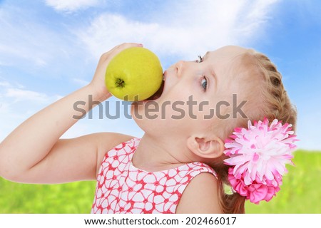 Girl biting a big juicy apple mouth wide open.healthy food concept,active lifestyle,happiness concept,carefree childhood concept.