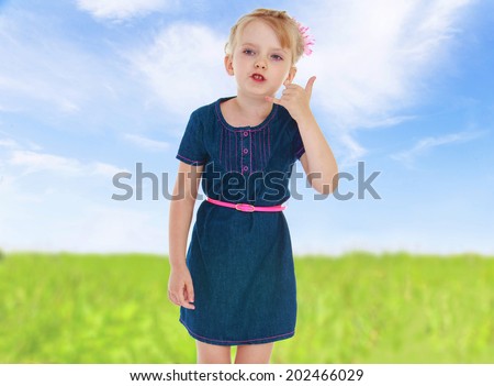 girl put her hand to her ear and shows that she wants to call.cheerful summer holiday,active lifestyle,happiness concept,carefree childhood concept.