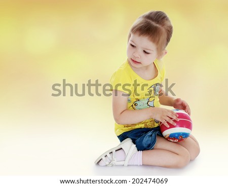 young girl in yellow shirt and ball in his hands.ball game,active lifestyle,happiness concept,carefree childhood concept.