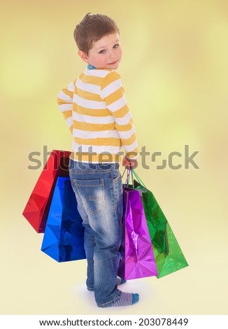 little boy in colorful bags goes to the store.the joy of shopping, Christmas gifts.happiness concept,happy childhood,carefree childhood,active lifestyle