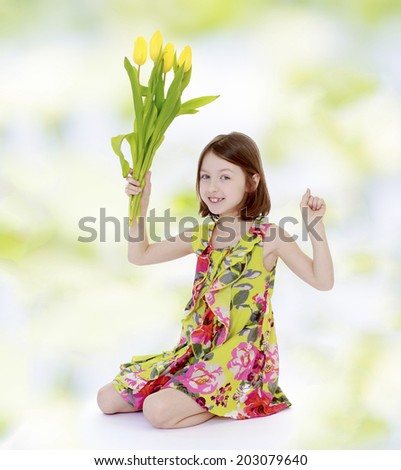 girl sitting on a column and holding a bouquet of flowers.floral bouquet, flowers delight,happiness concept,happy childhood,carefree childhood,active lifestyle
